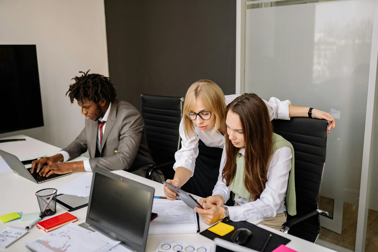 Illustrative photograph of three professionals reviewing documents together