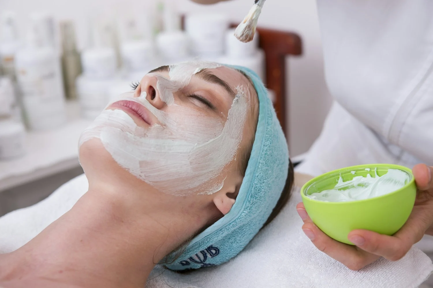 Therapist applying a facial mask during a skincare treatment